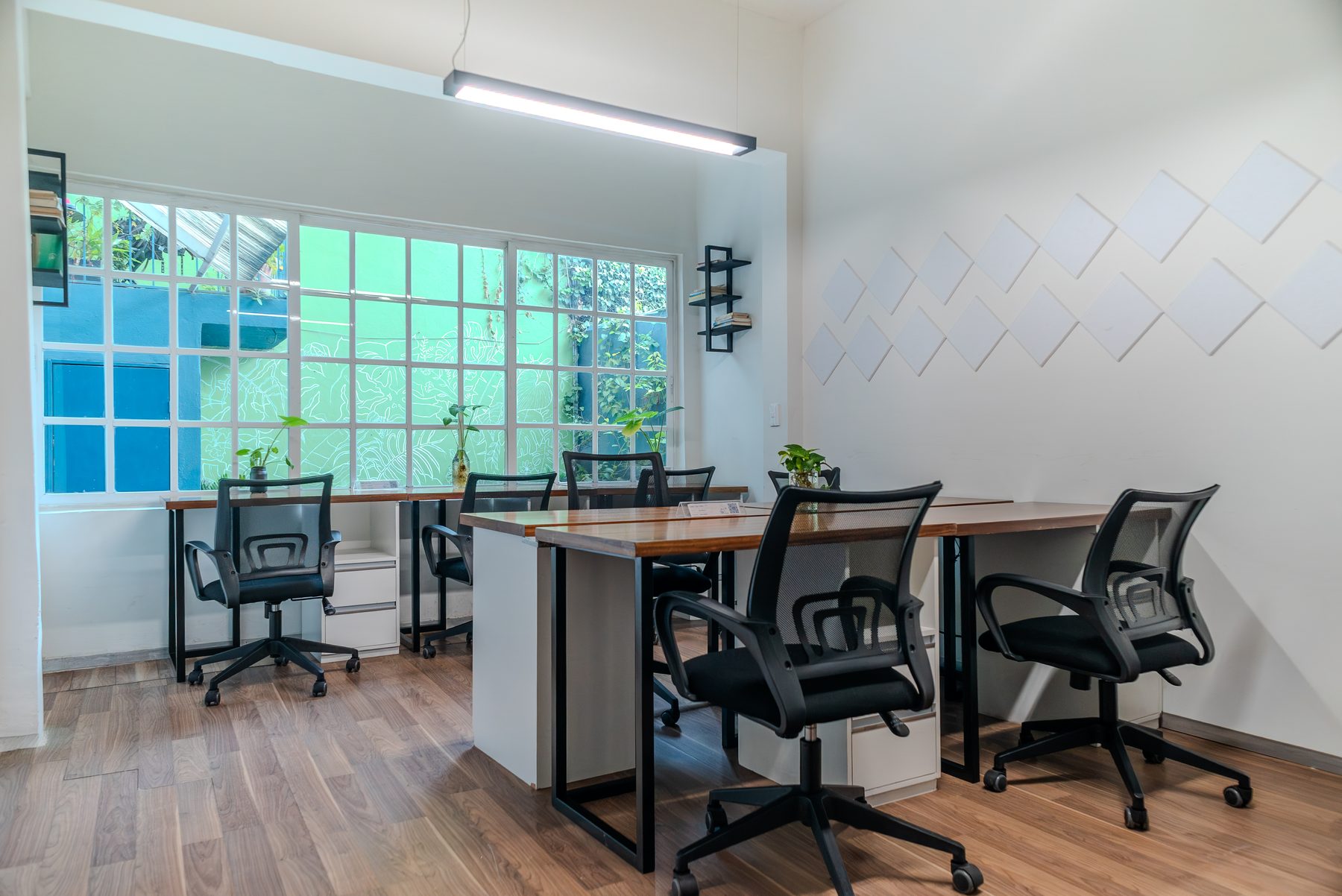 área de coworking con escritorios junto a ventanales