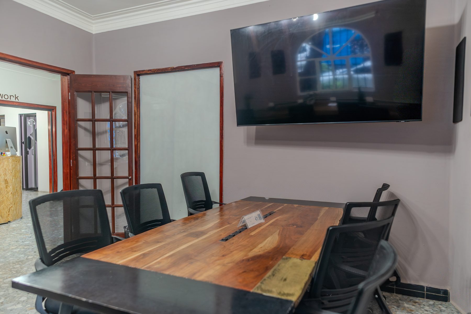 sala de juntas con pantalla y mesa de madera